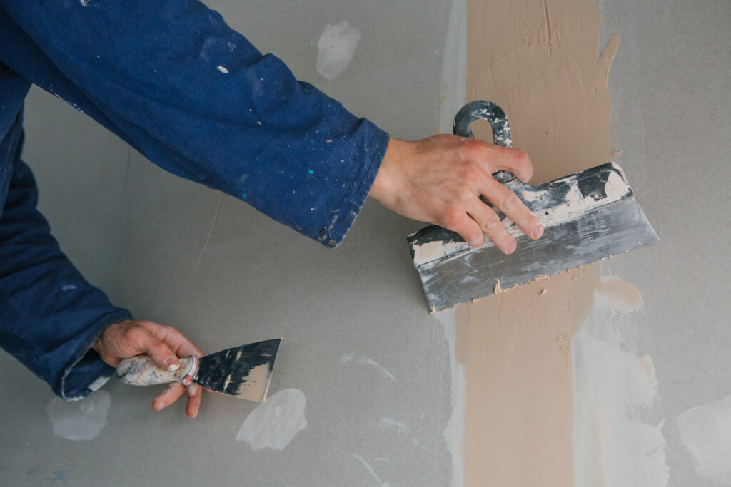 Applying finishing putty in wall